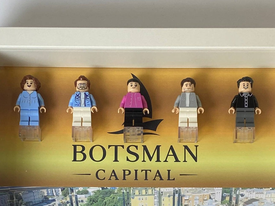 Рамка Botsman Capital: 5 фігурок на золотому фоні з логотипом